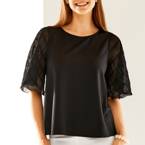 Woman in black top with butterfly sleeves