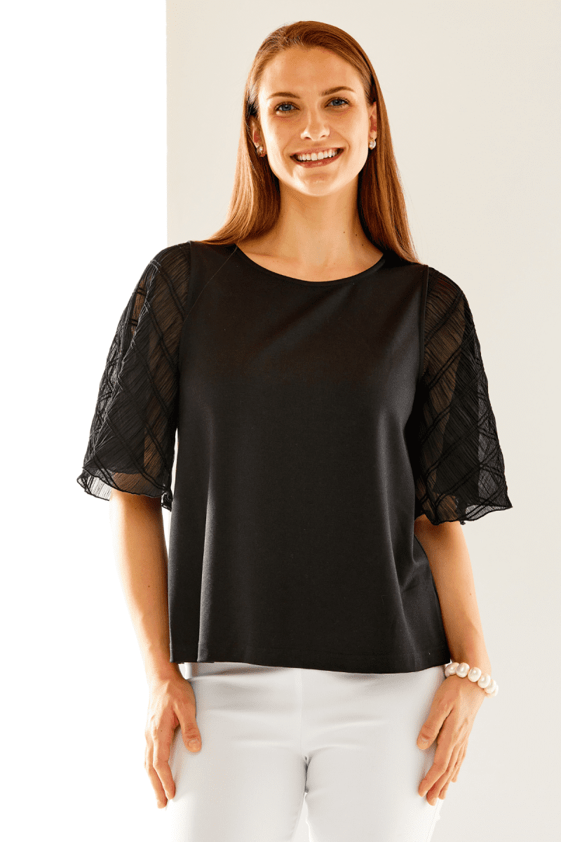 Woman in black top with butterfly sleeves