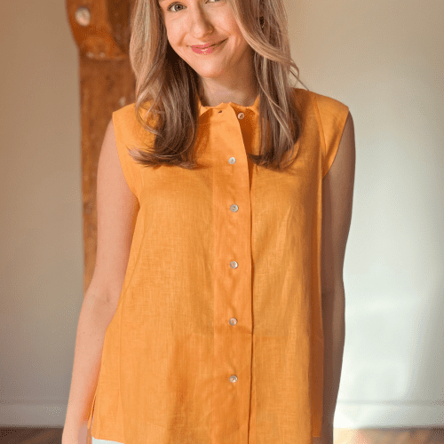 Woman in tangerine sleeveless linen top