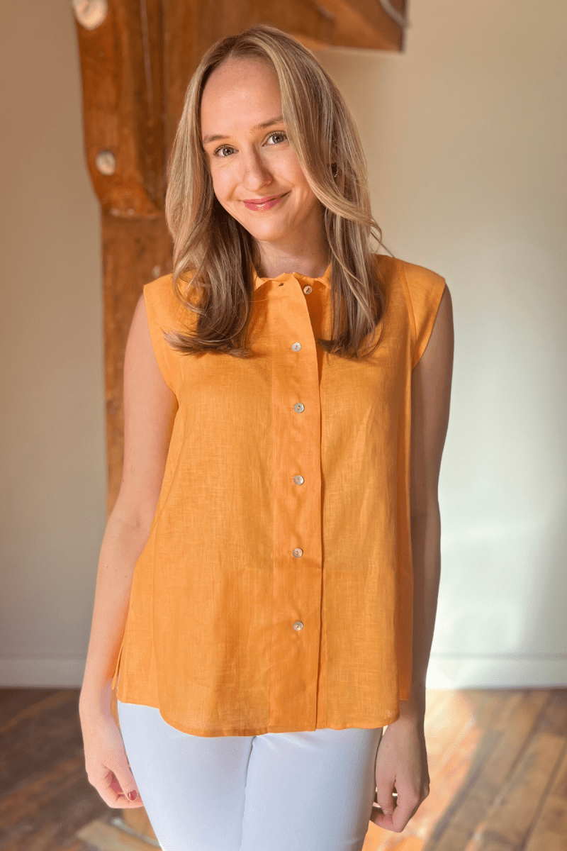 Woman in tangerine sleeveless linen top